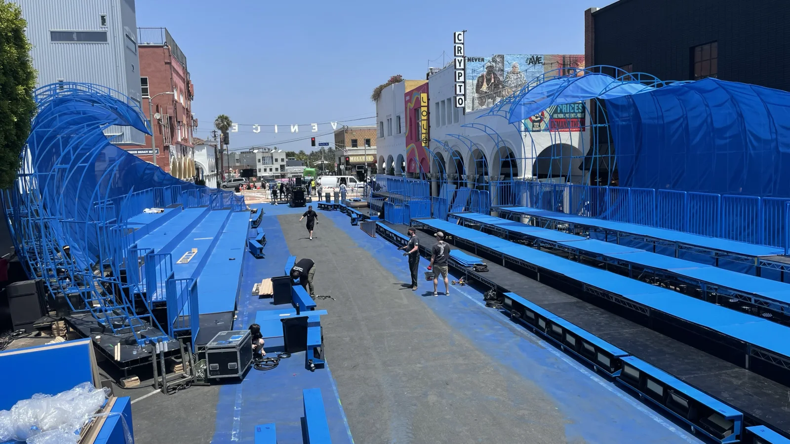 DIOR HOMME — The build by day: the blue waves and the bleachers, in full sun