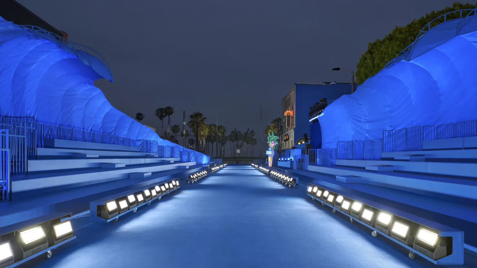 DIOR HOMME — The runway at ground level: the lights on and a wave on either side
