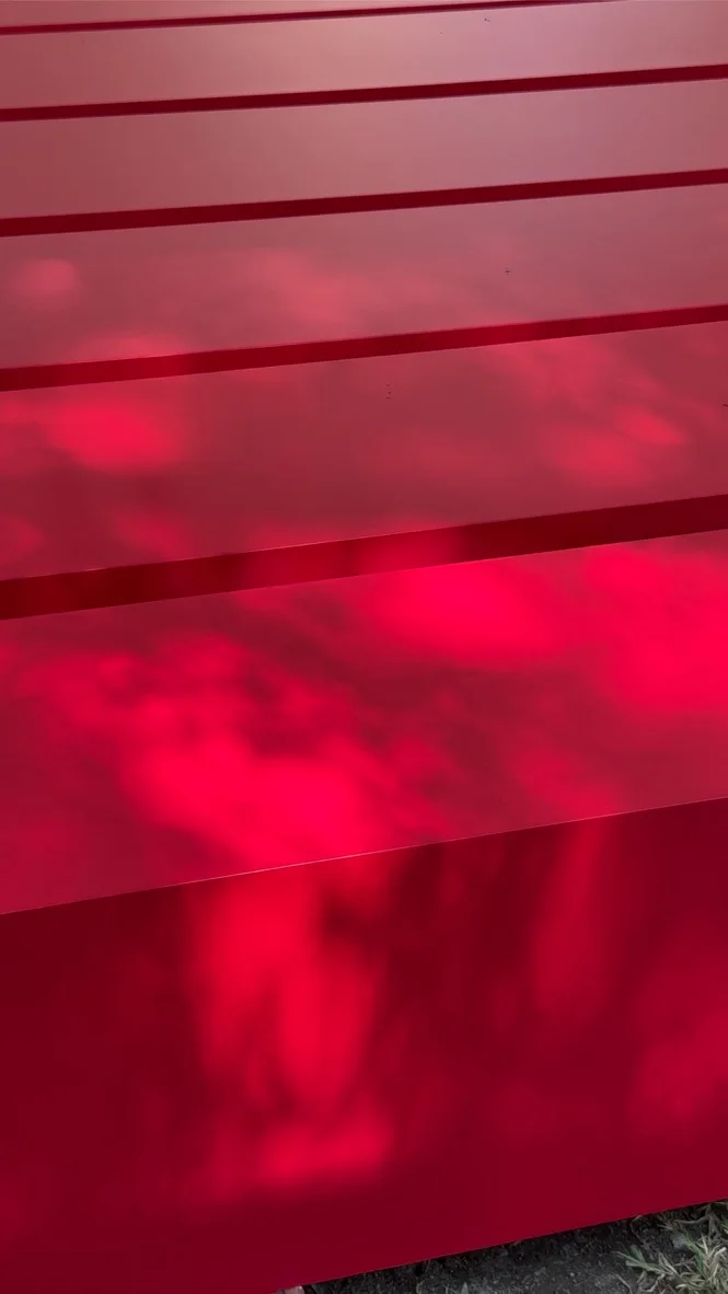 CAROLINA HERRERA — The red panels, up close: the sky reflected on the lacquer