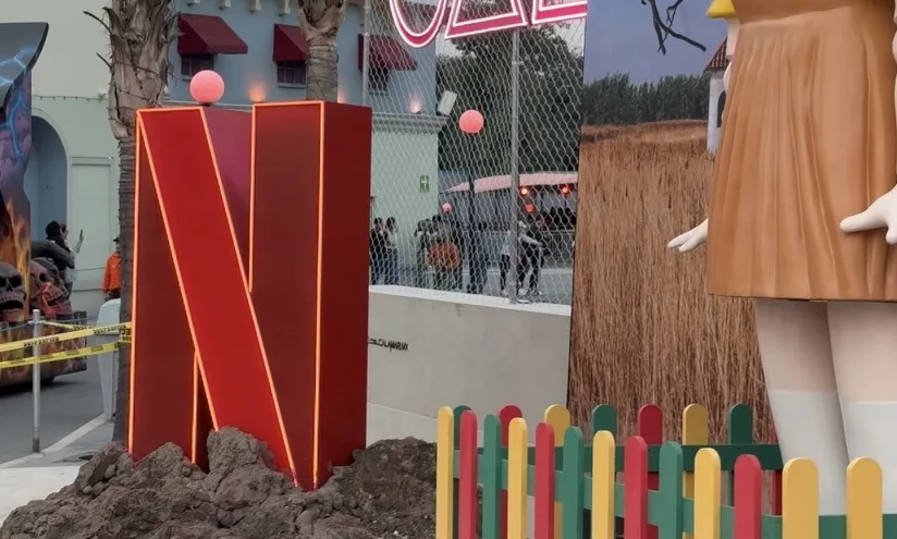 SQUID GAME — The red N and the doll, from the side, with the colored fence