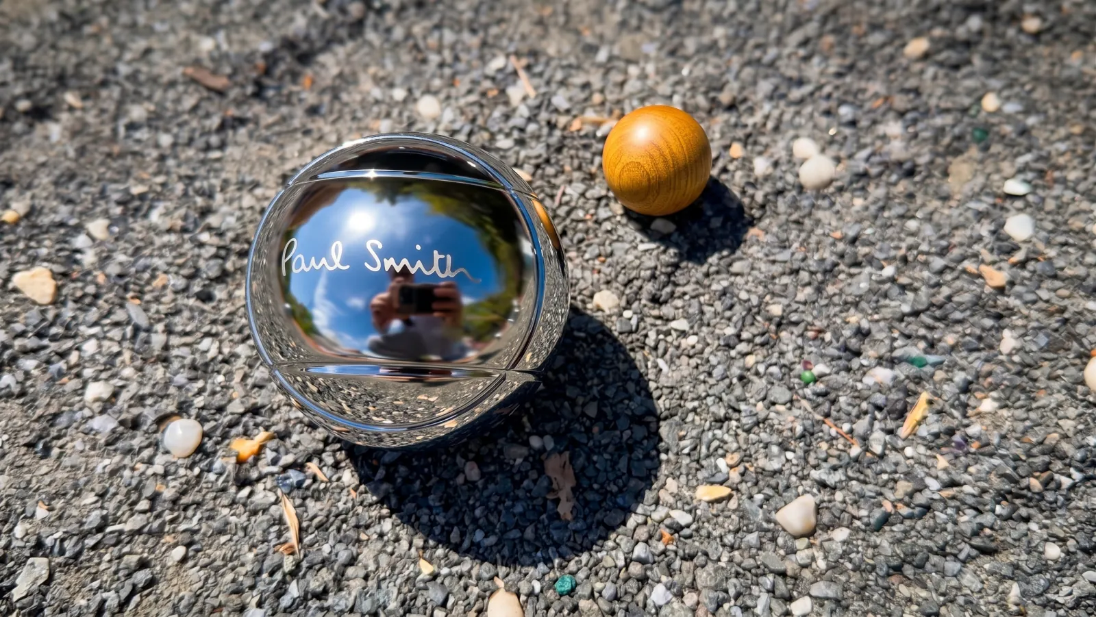 PAUL SMITH — A pétanque ball on the gravel, the signature engraved